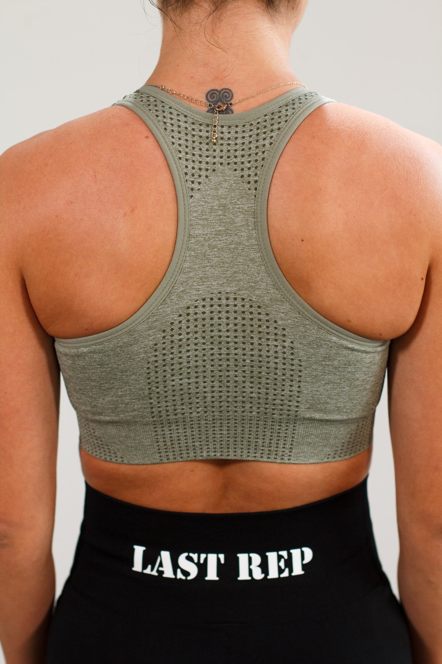 Last Rep green sports bra and Last Rep black biker shorts