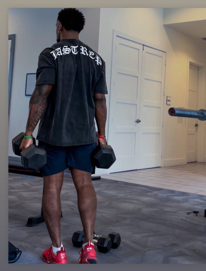 Person lifting dumbbells in a room with a door and wall in the background wearing black Last Rep pump cover