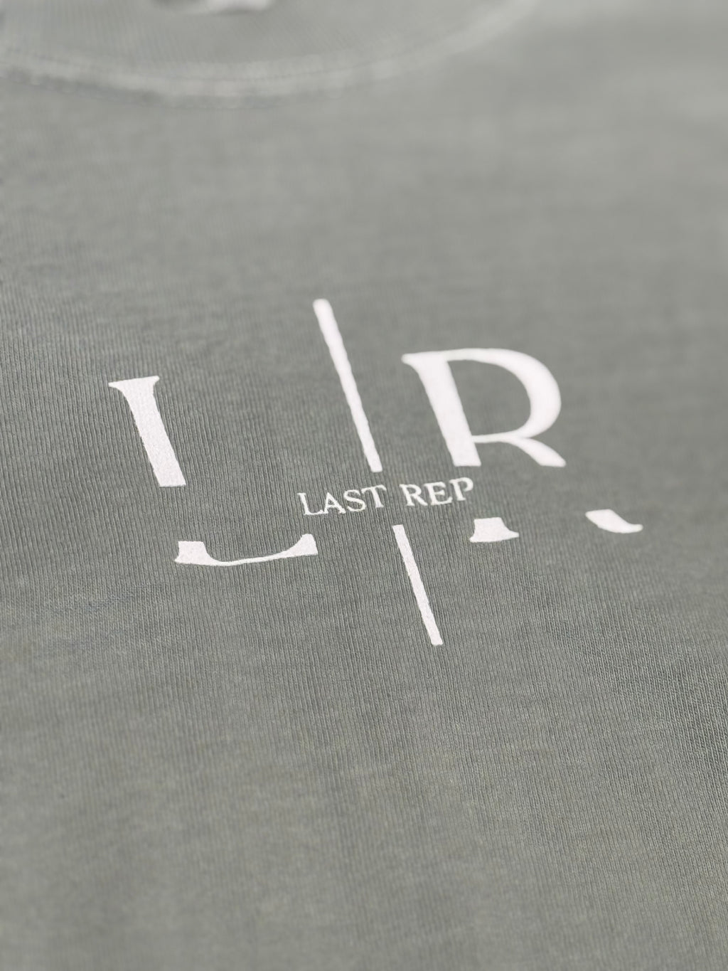 green t-shirt with 'Last Rep' logo in white on a close-up view