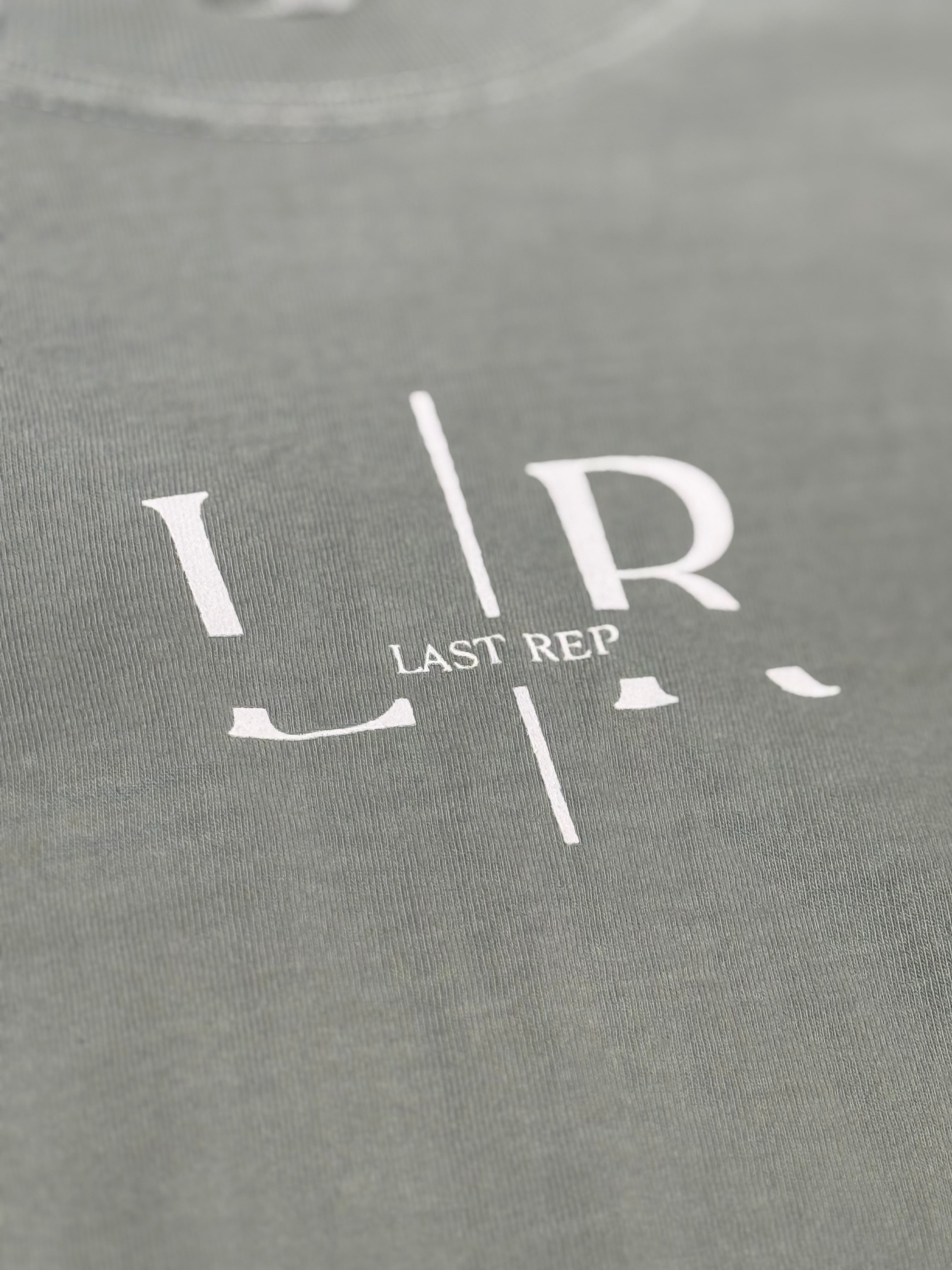 green t-shirt with 'Last Rep' logo in white on a close-up view