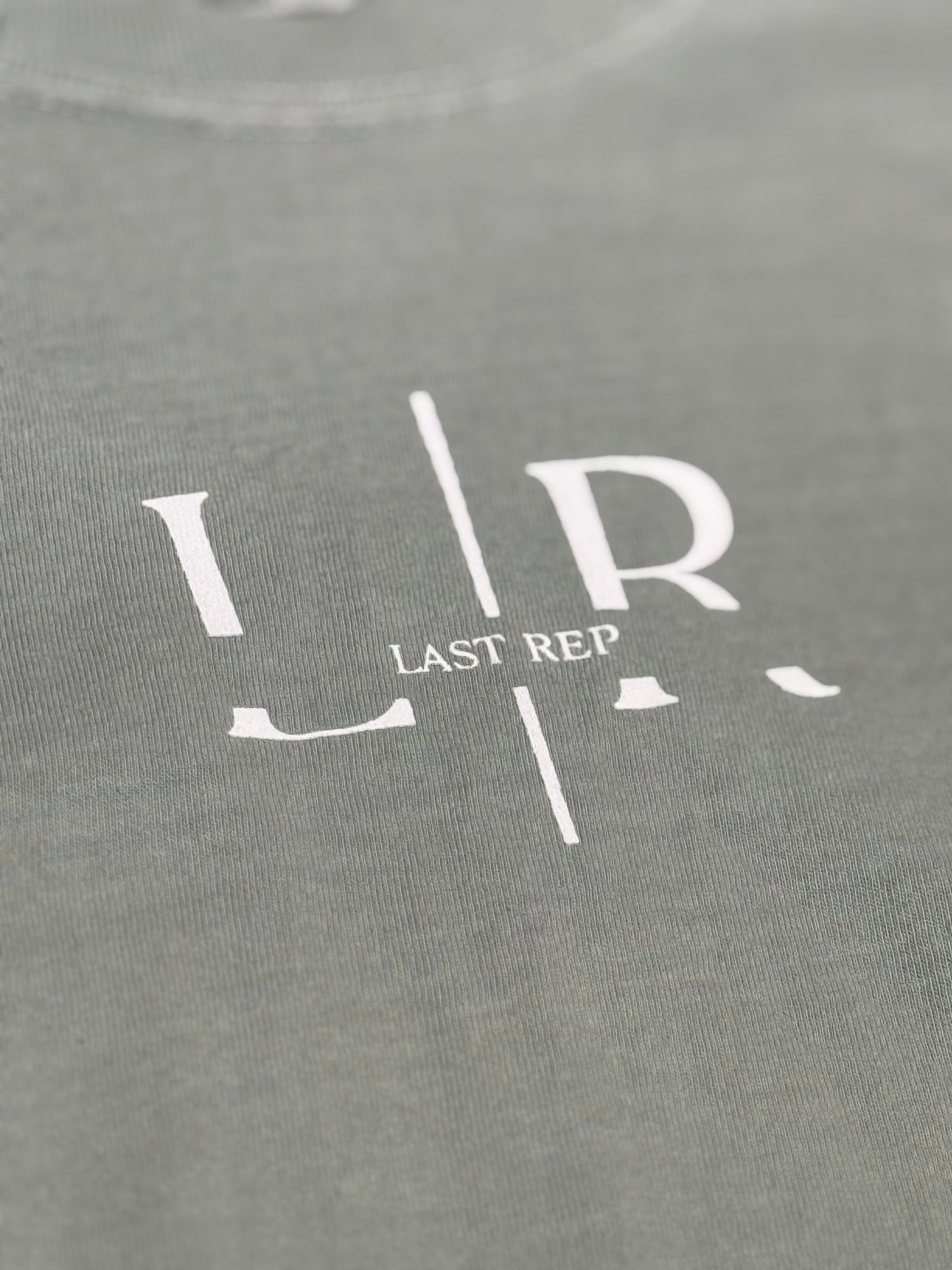 green t-shirt with 'Last Rep' logo in white on a close-up view