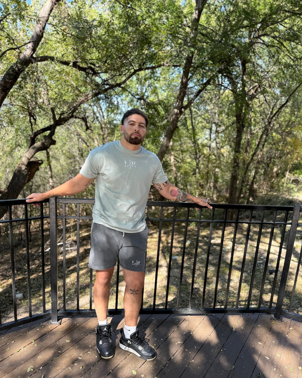 Man standing on a wooden deck with trees in the background