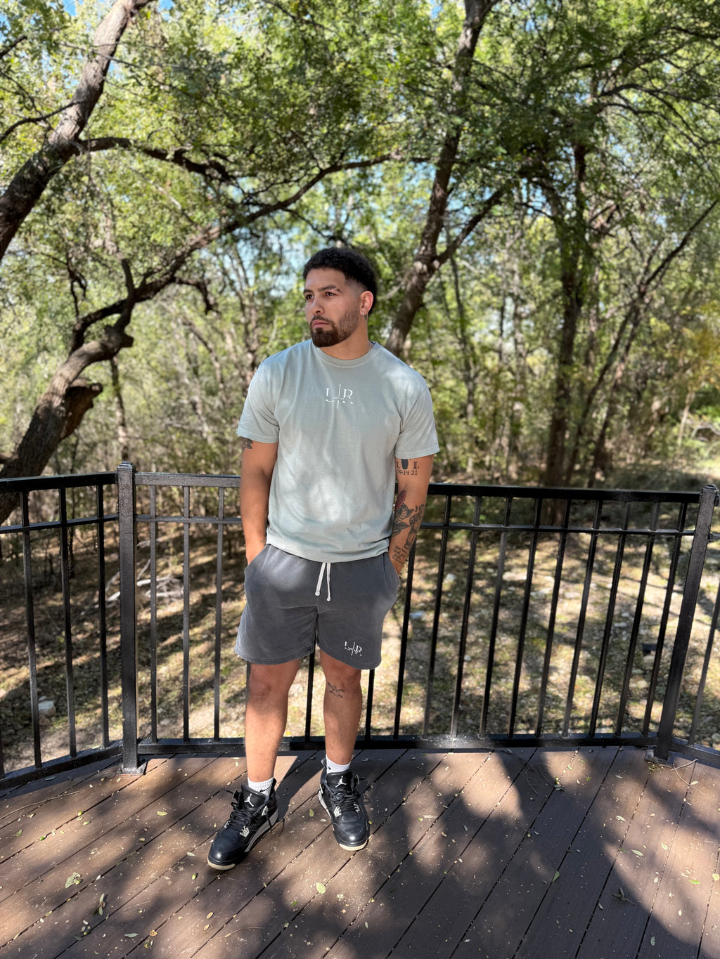 Man standing on a wooden deck with trees in the background