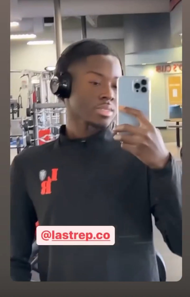 Person wearing a black Last Rep sweatshirt with a logo and text, taking a mirror selfie.