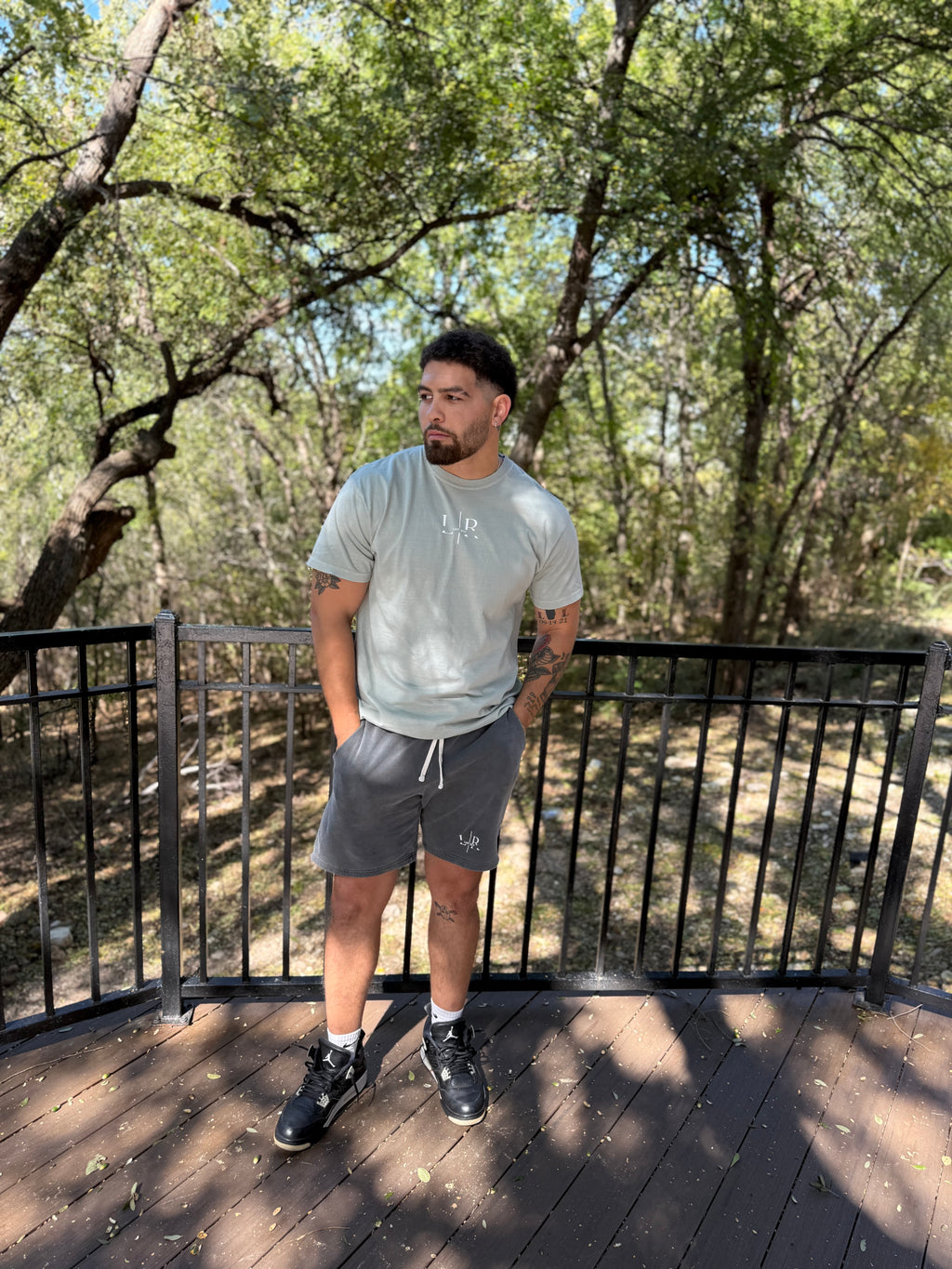 Man standing on a wooden deck with trees in the background