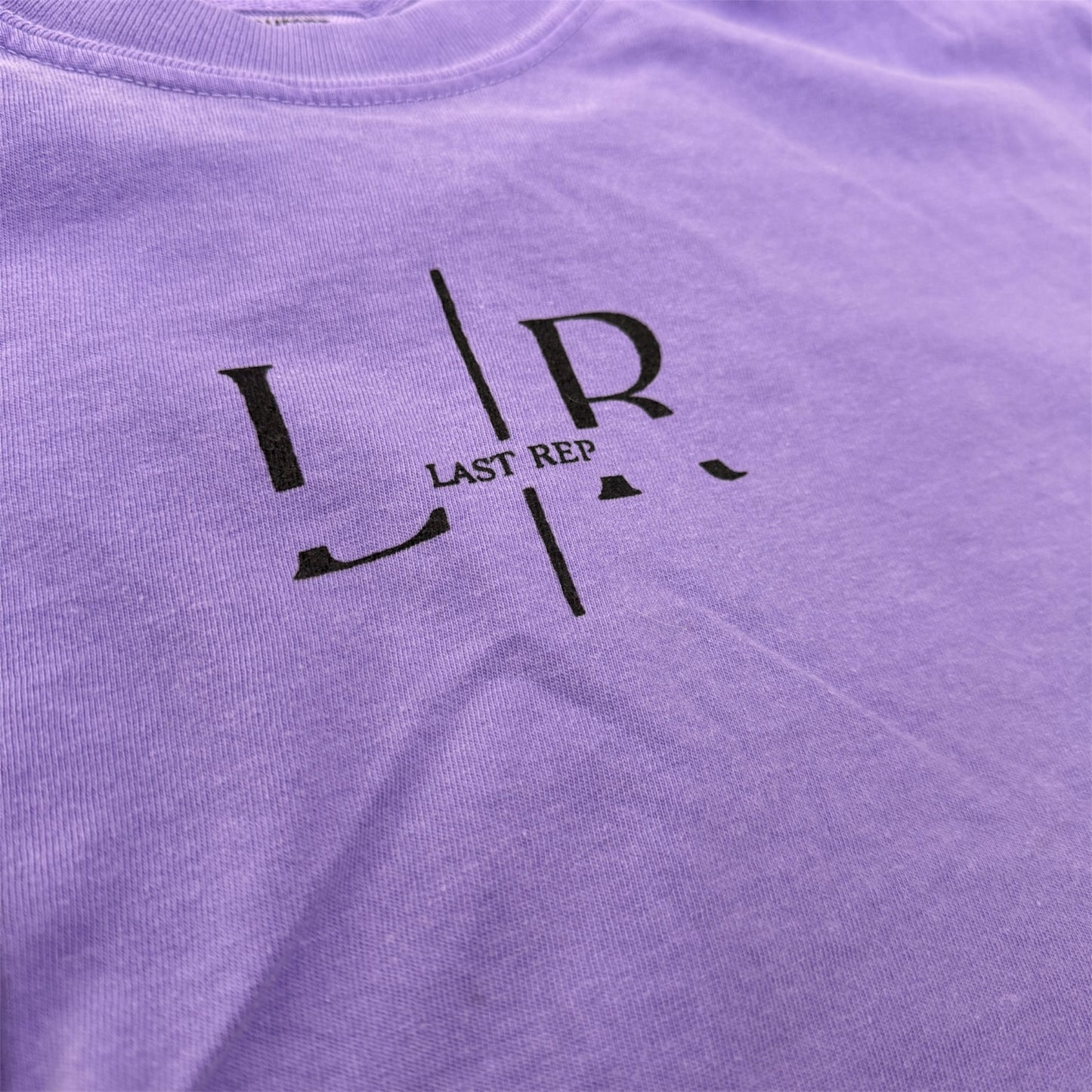 Purple shirt with black logo and text 'LR LAST REP' on a plain background
