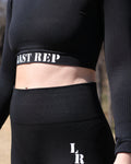 Person wearing black leggings with 'Last Rep' branding on a blurred background