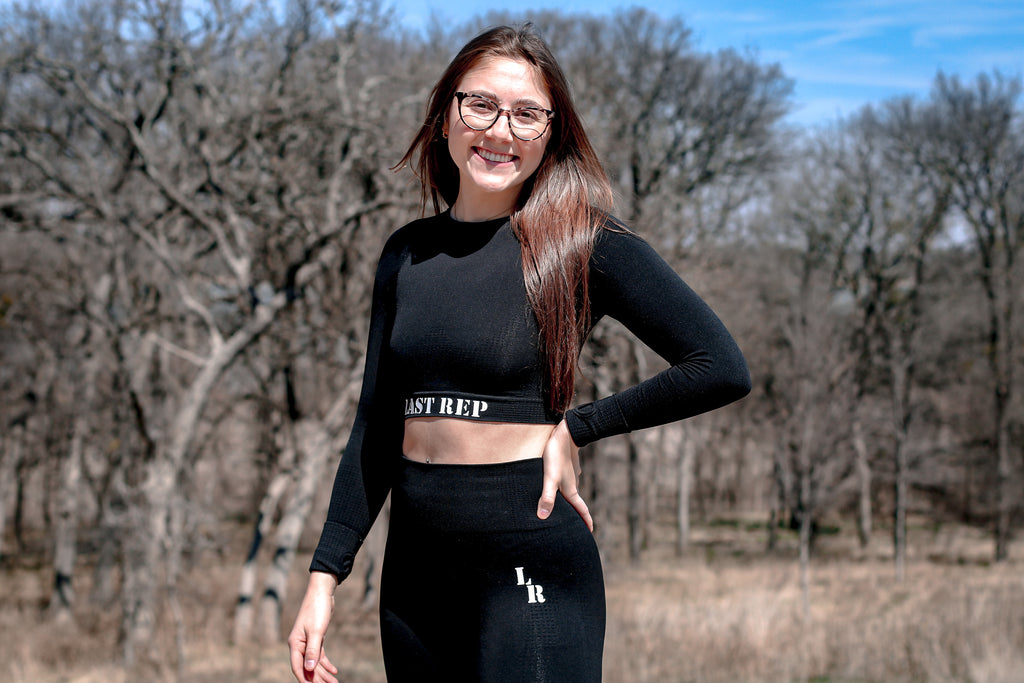 woman wearing black Last Rep crop long sleeve and leggings yoga set