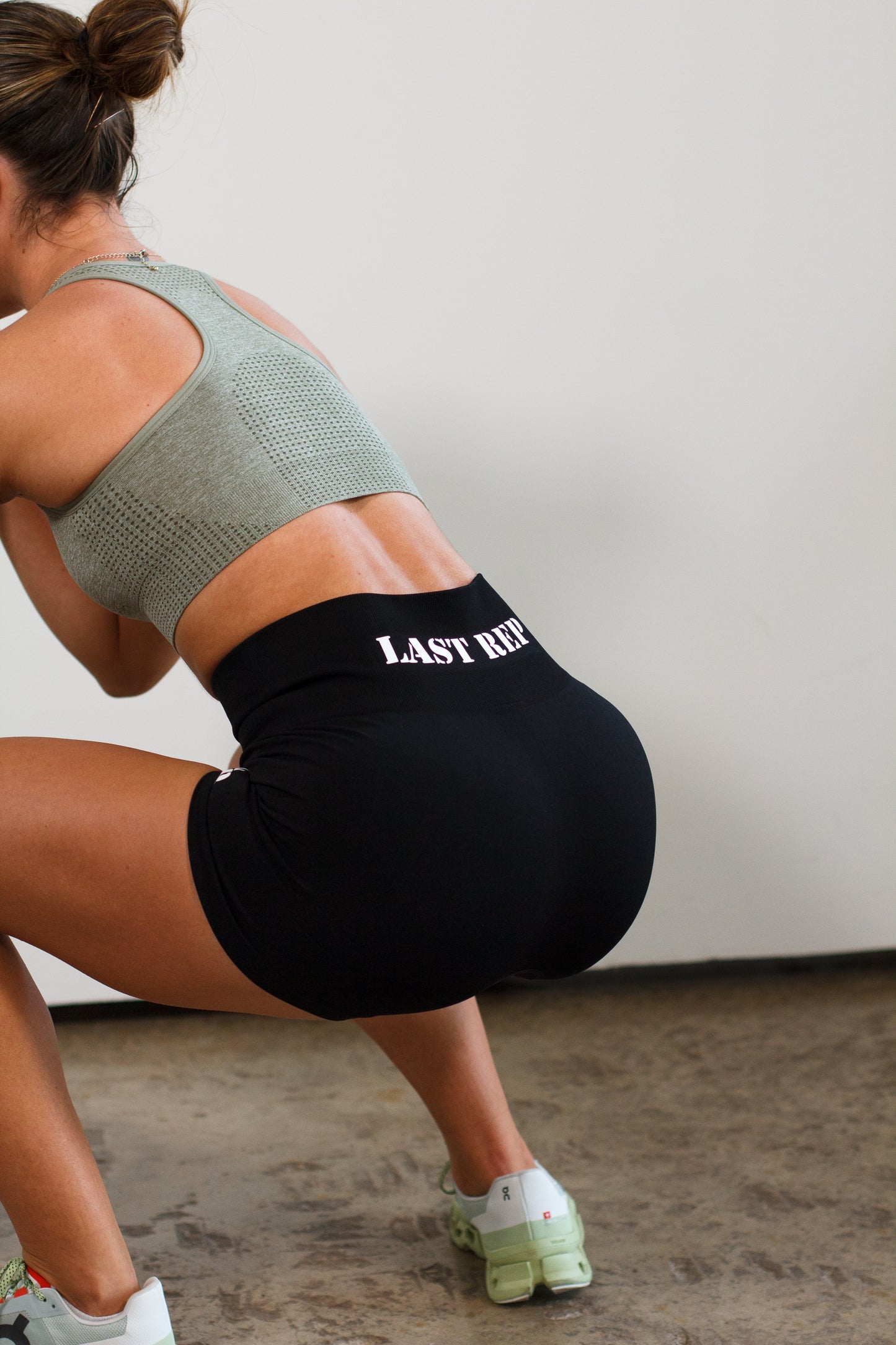 woman squatting with black Last Rep biker shorts