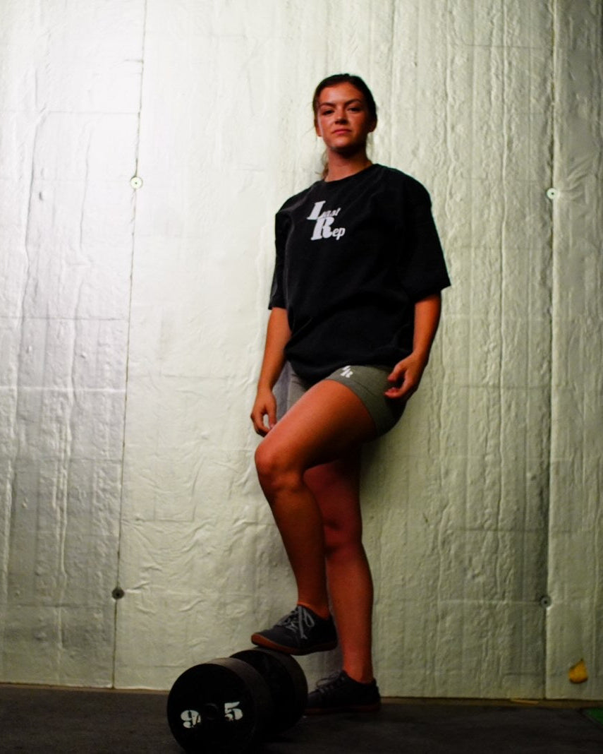 woman wearing last rep bike shorts and oversized last rep shirt