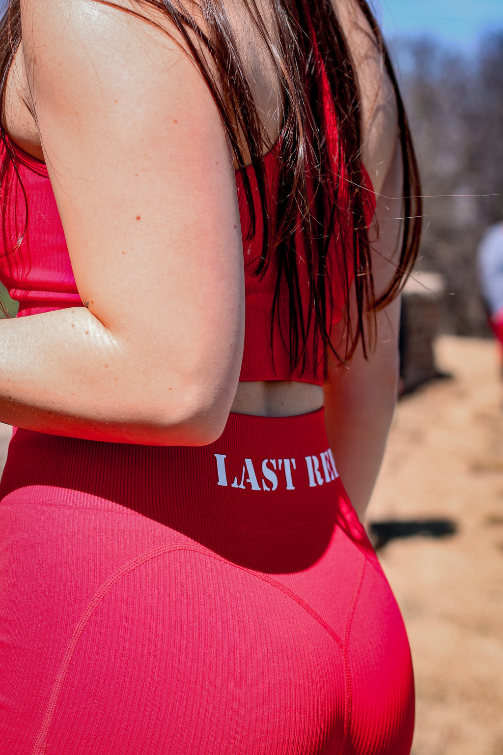 woman wearing red Last Rep biker shorts outside