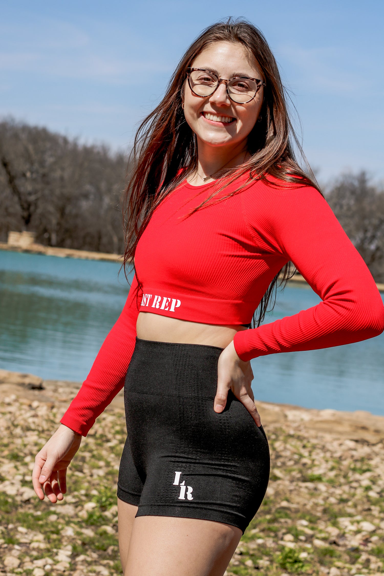 woman wearing red Last Rep long sleeve crop and black Last Rep biker shorts