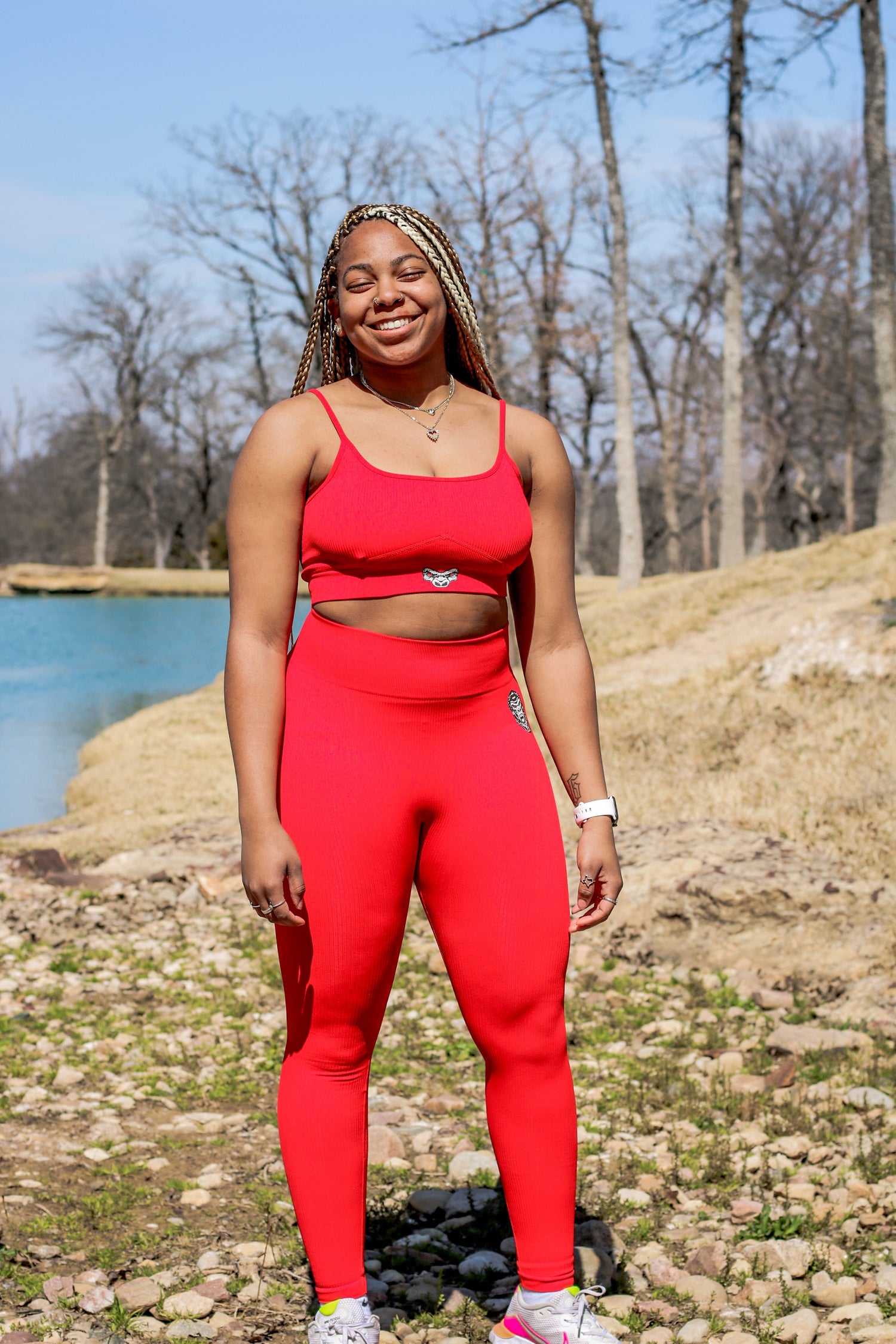 woman wearing red spaghetti strap Last Rep sports bra and leggings